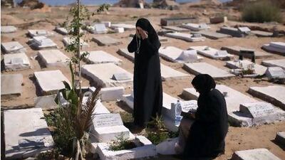 Jeria Birn Ismail, left, prays yesterday at the grave of rebel fighters who were killed in Tripoli fighting against Qaddafi's troops. Alexandre Meneghini / AP Photo