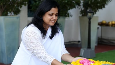 Nilanthi Wimalaweera makes an offering by the bodhi tree. Chris Whiteoak / The National