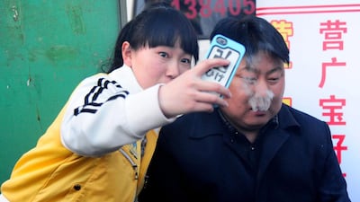 A girl takes a selfie with the Kim lookalike. AFP Photo
