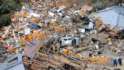 Volunteer firefighters search destroyed houses for missing people after heavy downpours by Typhoon Talas caused a landslide at Tanabe, central Japan, on Sunday.