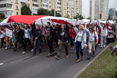 Anti-government protesters walk past riot police in Minsk, Belarus after the disputed August presidential election. Getty