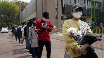 Voters wearing face masks wait in line to cast their ballots at a polling station during the parliamentary election in Seoul, South Korea. Reuters