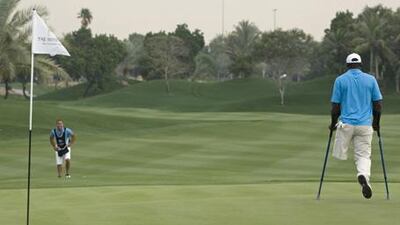 Manuel de los Santos gets around the Emirates Golf Course in Dubai during last month's invitational using his specially-crafted crutches.