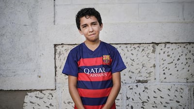 Alberto Argeñal, wearing the jersey of Spanish football team Barcelona, poses as he plays football in a neighbourhood of Managua, on January 13, 2016. Football is gaining enthusiasts in Nicaragua where baseball has been historically dominant but is now giving way to the new sport, analysts said. Inti Ocon / AFP