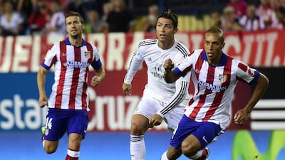 Real Madrid’s Cristiano Ronaldo, centre, in hot pursuit of the ball with Miranda, right, and Gabi of Atletico Madrid last August. The Madrid derby is one of the most eagerly anticipated matches in Spain. Gerard Julien / AFP