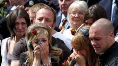 Mourners cry as hearses carry the bodies of four soldiers who died in Afghanistan through Wootton Bassett, Wiltshire, England, yesterday.