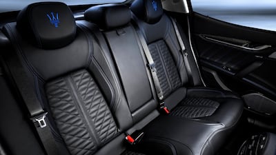 The Hybrid version has a blue-tinted badge, while the cabin's leather features blue stitching and embroidery throughout