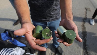 A protestor displays empty tear gas canisters fired by security forces. AFP