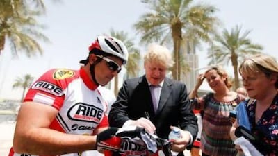 Shahriar Khodjasteh, president of Dubai Desert Extreme, gets a cycling jersey autographed by Mr Johnson. Sarah Dea / The National