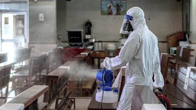 A sanitation worker disinfects the prayer hall after mass.