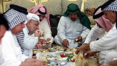 Iraqi men eat a traditional Eid meal of masmouta in Basra. Reuters