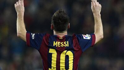 Barcelona's Lionel Messi celebrates after scoring one of his three goals against Sevilla on Saturday in a La Liga victory. Lluis Gene / AFP