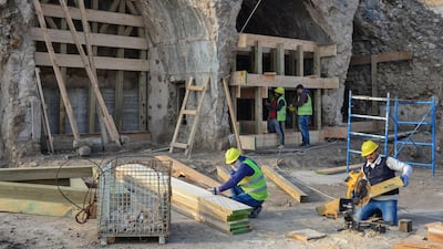 Iraqi workers build wooden supporting structures during the reconstruction of "Al-Hadba" leaning minaret in Mosul rebuilding. AFP