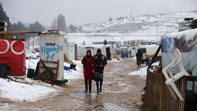 Two Syrian women from Raqqa walk through a Syrian refugee camp in the Bekaa Valley in Lebanon after the first heavy snow storm hit Lebanon, January 3, 2016. REUTERS/Jamal Saidi - GF10000281622