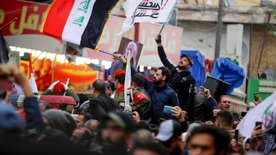 Mourners wave the national flag and the Hashed al-Shaabi flag as they carry the portrait of Iraqi paramilitary chief Abu Mahdi al-Muhandis during a funeral procession, for Muhandis and Iranian military commander Qassem Suleimani, in Kadhimiya, a Shiite pilgrimage district of Baghdad. AFP