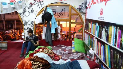 An Iraqi demonstrator reads a newspaper at a makeshift library in an abandoned Turkish building during the ongoing anti-government protests in Baghdad. Reuters