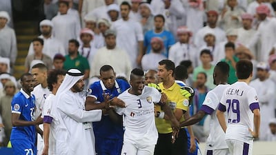 Al Ain's Asamoah Gyan, is restrained after getting a red card against Al Hilal in the semi-final second leg of the Asian Champions League on Tuesday. Ravindranath K / The National