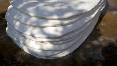 Large rubber slabs are stacked before being pressed flat and dried. Paula Bronstein / Getty Images