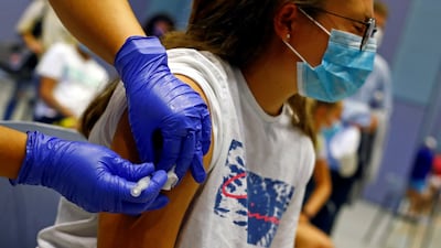 A nurse administers the first dose of the Moderna vaccine to Tatiana Suarez, 15, in Spain on July 28, 2021. Reuters
