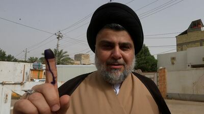 Moqtada Al Sadr shows his ink-stained finger after casting his vote. Alaa al-Marjani / Reuters