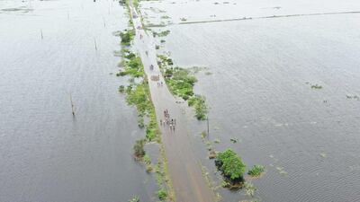 Residents wading through flood water to cross a road near Maputo, Mozambique. AFP