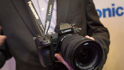 An exhibitor holds a Panasonic Lumix S1R camera. Bloomberg