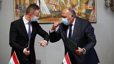 Hungarian Minister of Foreign Affairs and Trade Peter Szijjarto, left, and Egyptian Foreign Minister Sameh Shoukry bump their arms after signing an agreement in Cairo, Egypt. EPA