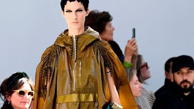 In the hands of Dries Van Noten, a workaday rain mac is elegant, worn with cropped trousers and striped shoes. AFP