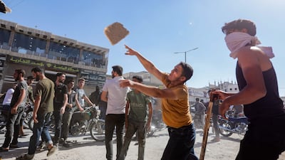 A protester throws a rock at a Turkish lorry in Al Bab. AFP