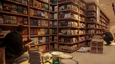 Workers arrange bookshelves ahead of the opening of the new Samir Mansour bookshop that was destroyed during last year's 11-day war between Israel and the Palestinian Hamas movement, in Gaza City.