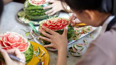 Close up of student hands craving on the watermelon. Sasamon Rattanalangkarn for The National