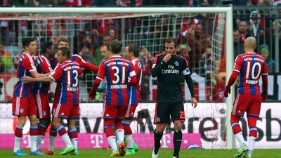 Bayern Munich players celebrate with goal-scorer Thomas Mueller while Hamburg captain Rafael van der Vaart looks on. Alexander Hassenstein / Getty Images