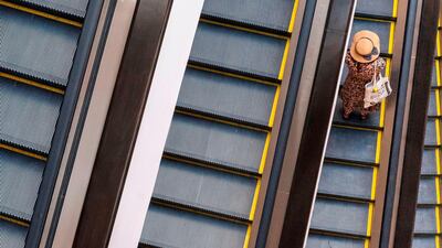 A visitor rides an escalator at a shopping mall in downtown Bangkok. AFP