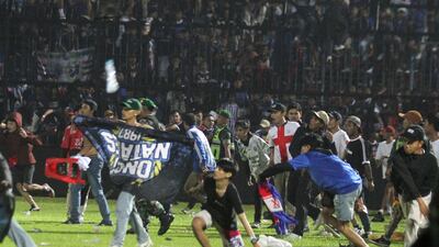 Arema FC supporters enter the field after the team they support lost to Persebaya on October 2. Reuters