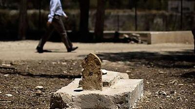 An Israeli man walks past Muslim tombs in the Mamilla cemetery near the construction site of the Museum of Tolerance in Jerusalem.