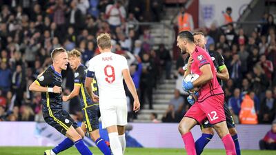 Arijanet Muric of Kosovo is congratulated by team mates after saving a penalty.