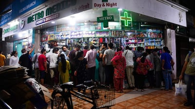 People gather at a pharmacy to buy supplies following Indian Prime Minister's announcement of a government-imposed nationwide lockdown, in Mumbai. AFP