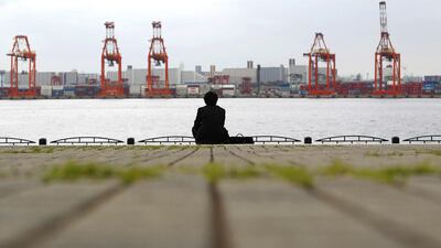 A businessman sits near a cargo area at a port in Tokyo. Economy Minister Akira Amari said some economic stimulus was likely, but added it would be hard to craft an exceptionally big package because of the need for fiscal discipline. Toru Hanai / Reuters