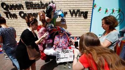 Journalists and curious onlookers stop to photograph and interview a royal enthusiast camped outside St Mary's Hospital where Catherine, Duchess of Cambridge, was brought in to deliver her first baby in central London.