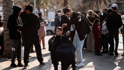 A boy receives a haircut on the Corniche in Beirut. AFP