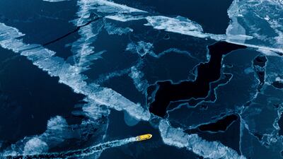 A boat rides though a frozen sea inlet outside of Nuuk, Greenland. AP Photo