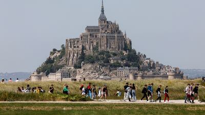 Tourists walk around Le Mont-Saint-Michel abbey, a Unesco heritage site in France, 1,000 years since the first stone was laid. AP