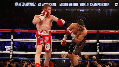 Saul Alvarez lands a left hook on his way to a sixth round stoppage win over Amir Khan. Christian Petersen / Getty Images