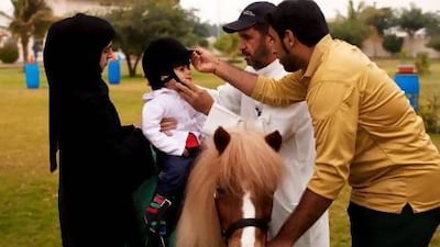 Moza Sultan Al Marri, 3, rides as part of a Community Development Authority scheme. Her mother, Alia, says Moza was slow to develop but her posture, communication and behaviour have now improved. Christopher Pike / The National
