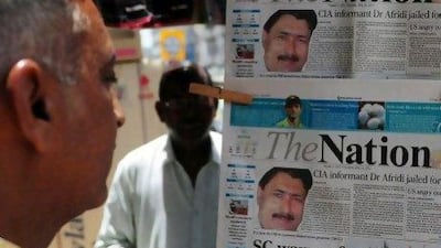 A man reads a newspaper in Karachi which headlines the sentencing of the Shakil Afridi, the Pakistani surgeon recruited by the CIA to help find Osama bin Laden, to 33 years in prison for treason.