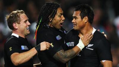 Isaia Toeava, right, is congratulated by teammates Ma'a Nonu, centre, and Andy Ellis after scoring one of New Zealand's 13 tries in their victory over Japan.