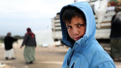 A displaced Syrian boy looks on as families gather their belongings as they prepare to leave a camp for the displaced, where they had sought refuge, on the outskirts of the town of Binnish in Syria’s northwestern province of Idlib. AFP