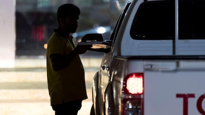 A man delivers karak to a car window in the parking lot outside Nena Tea. Chris Whiteoak / The National