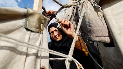 A Palestinian woman repairs a tent damaged by rain and wind in Gaza on Sunday. Gazans won't accept an international presence that feels imposed from the outside. Reuters