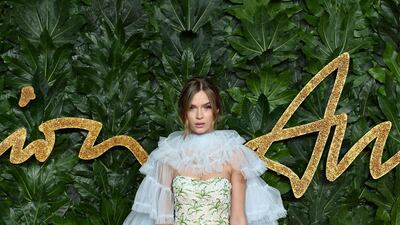 Josephine Skriver teams an embellished dress and matching boots with a tiered cape. Getty